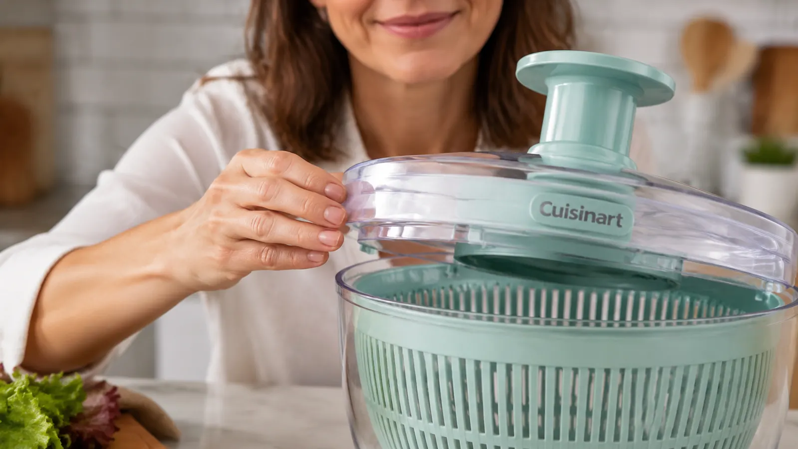 Hand aligning the lid tabs on the Cuisinart salad spinner before locking it into place